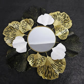 Wall mirror with decorative gold, black, and white ginkgo leaf frame"